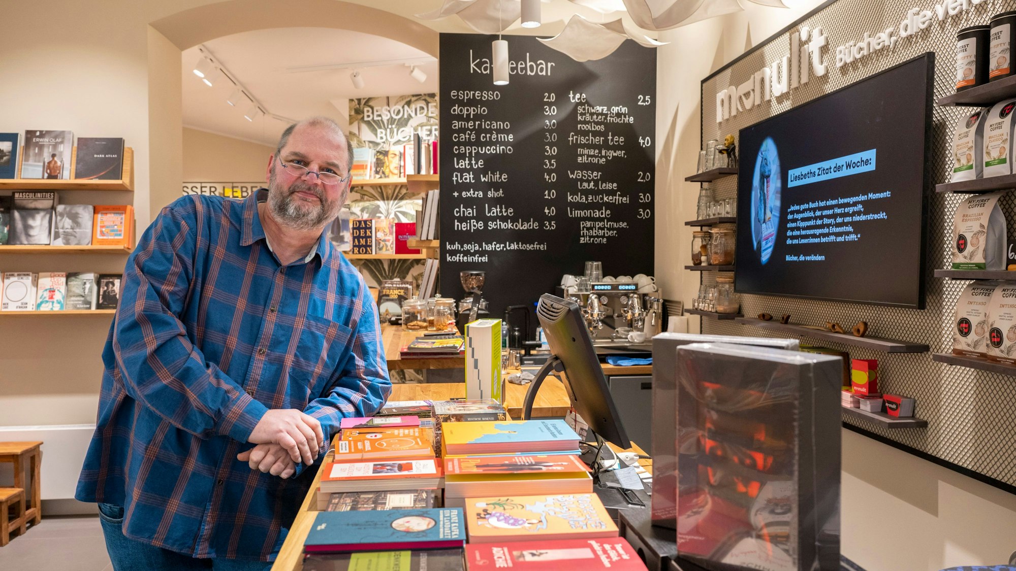 Urs Erdle steht in seinem Buchladen, im Hintergrund ist die Kaffeebar zu sehen.