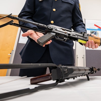 Ein Polizist zeigt eine sichergestellte umgebaute AK-47 Kalaschnikow.