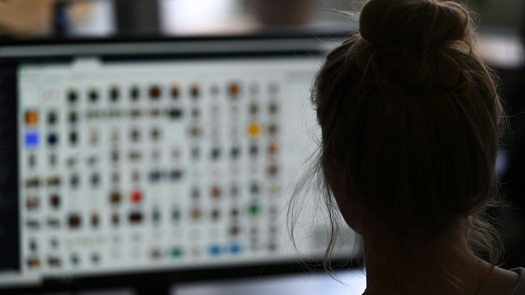 Eine Frau sitzt in einem Büro vor einem Auswertungscomputer auf der Suche nach Kinderpornografie und Fällen von sexuellem Missbrauch.