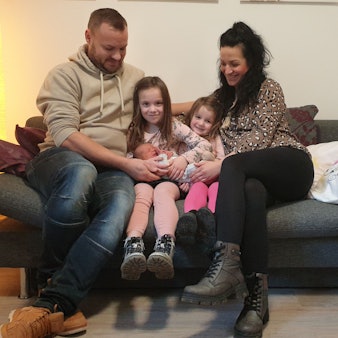 Das Euskirchener Neujahrsbaby Thilo Liam Okon im Arm seiner Familie: David Okon (l.), Susanne Okon mit den Kindern Lilli Alisa und Anni Mailin auf ihrer Couch.