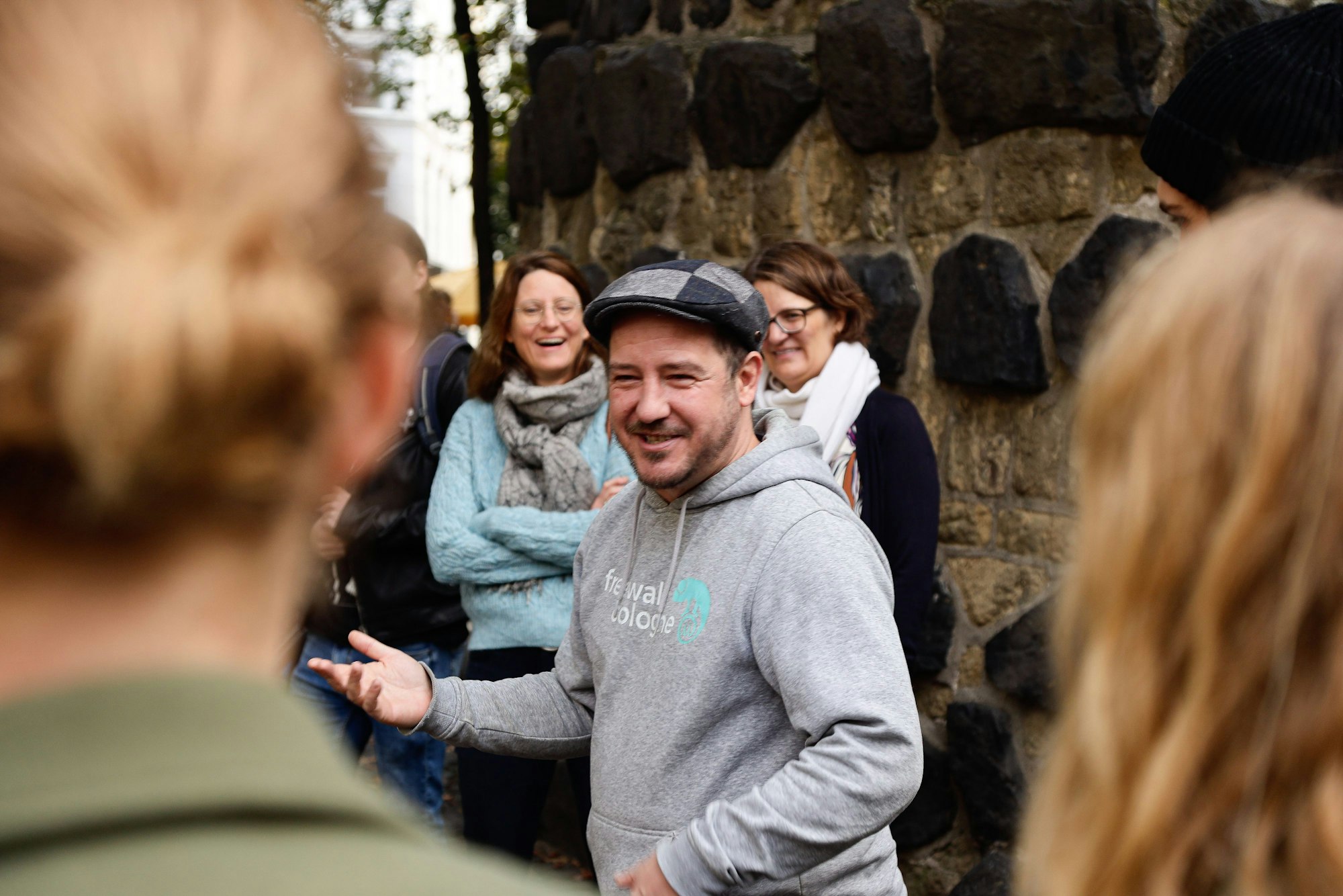 Matthias Boden steht zwischen einer Gruppe Menschen vor der Eigelsteintorburg und erzählt eine Geschichte.