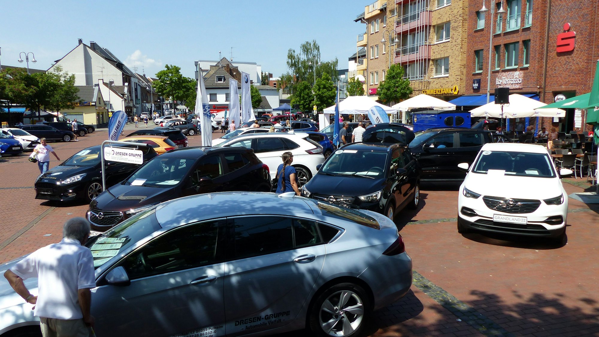 Mehrere Autos stehen auf dem Marktplatz in Pulheim bei einer Autoschau.