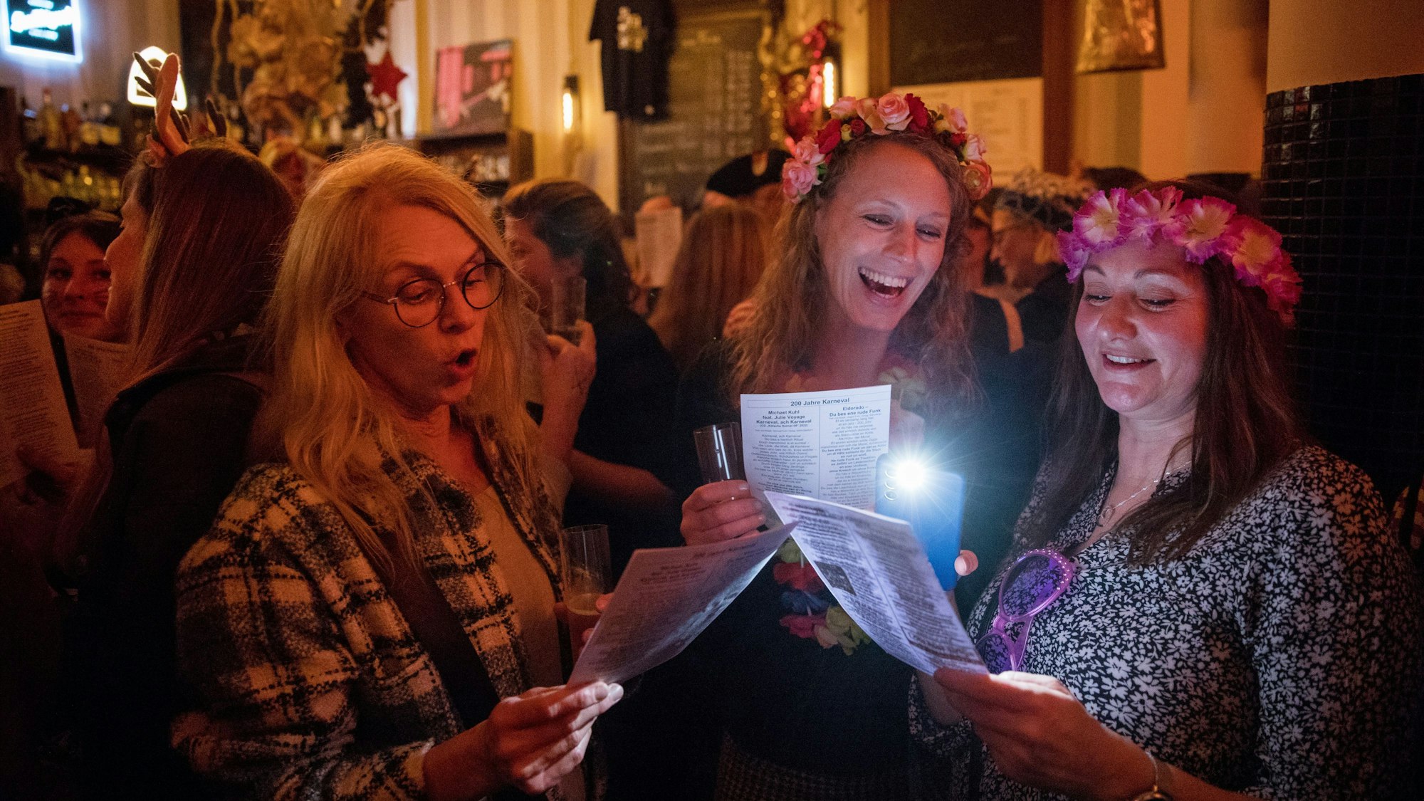 Drei Frauen mit Liedzetteln singen bei der Auftaktveranstaltung der Kneipentour von "Loss mer Singe" im Lapidarium.