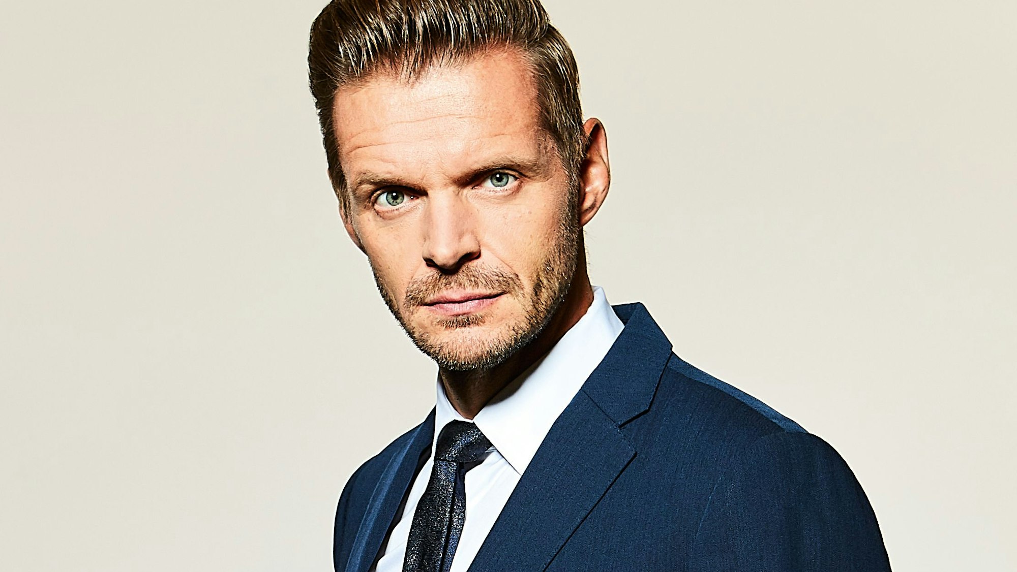 Kabarettist und Moderator Florian Schroeder im blauen Anzug im Porträt.