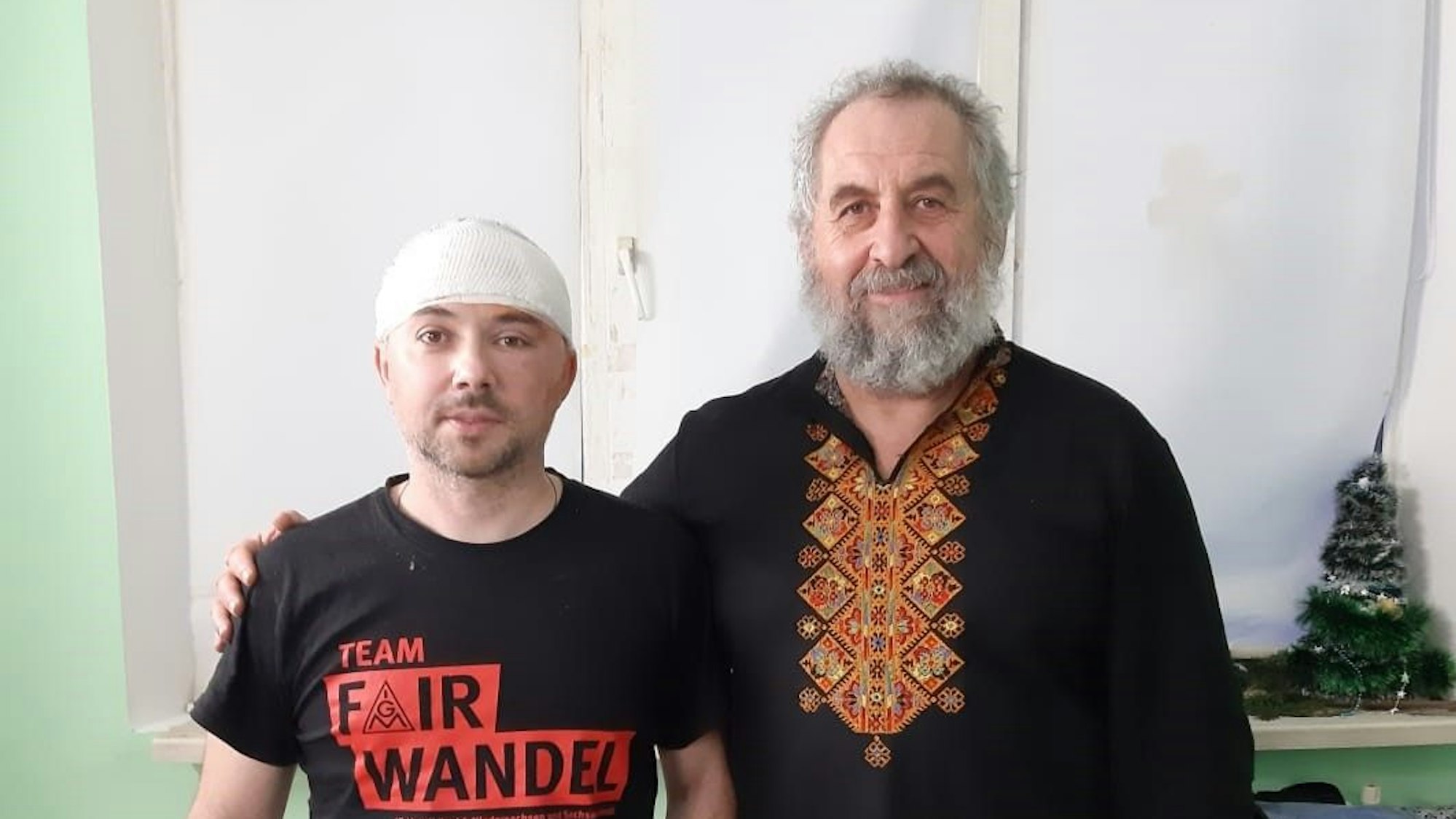 Paul Kruk steht Arm in Arm mit einem verwundeten Soldaten, der einen Turban trägt.