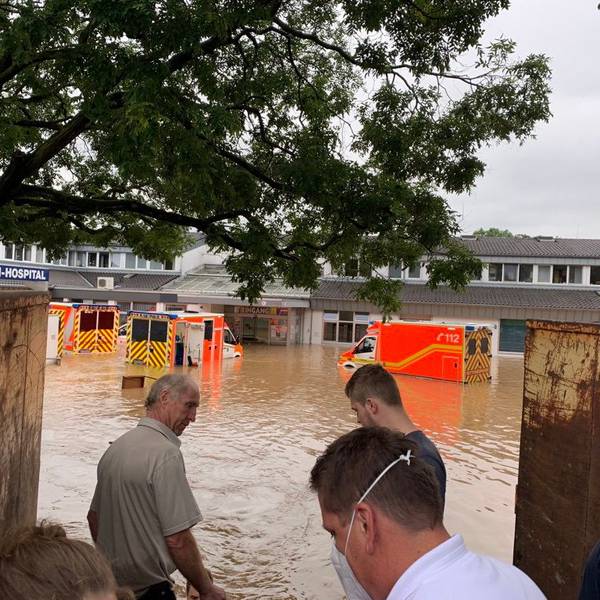 Ein Krankenhaus und mehrere Rettungswagen stehen unter Wasser.