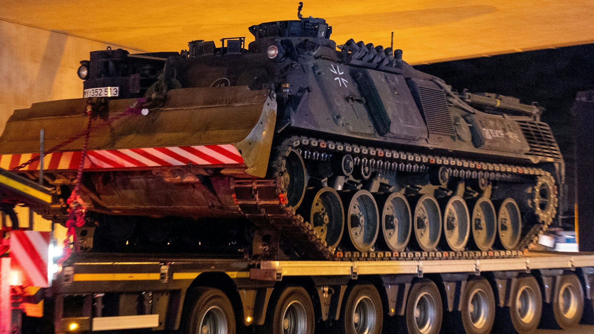 Ein Bergepanzer der Bundeswehr erreicht in der Nacht den Sammelplatz an einer Autobahnbrücke.