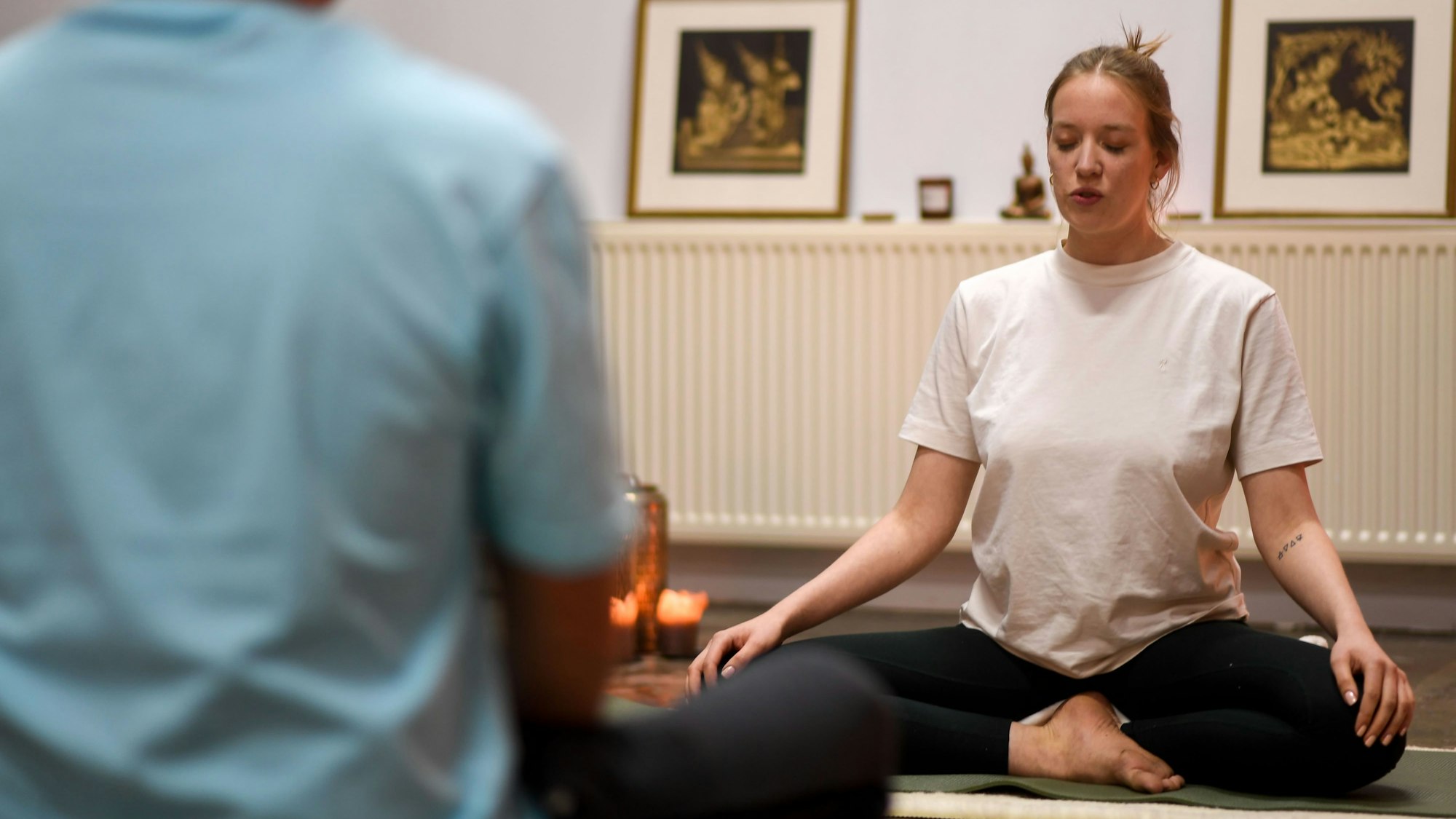 Stella und Tom sitzen im Schneidersitz gegenüber.