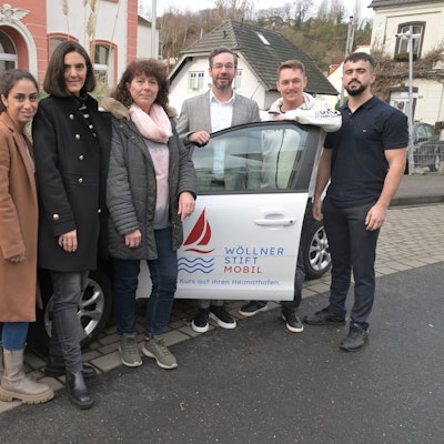 Das Team des Wöllner-Stifts steht in Rösrath-Hoffnungsthal vor dem weißen Wöllner-Stift-Mobil.
