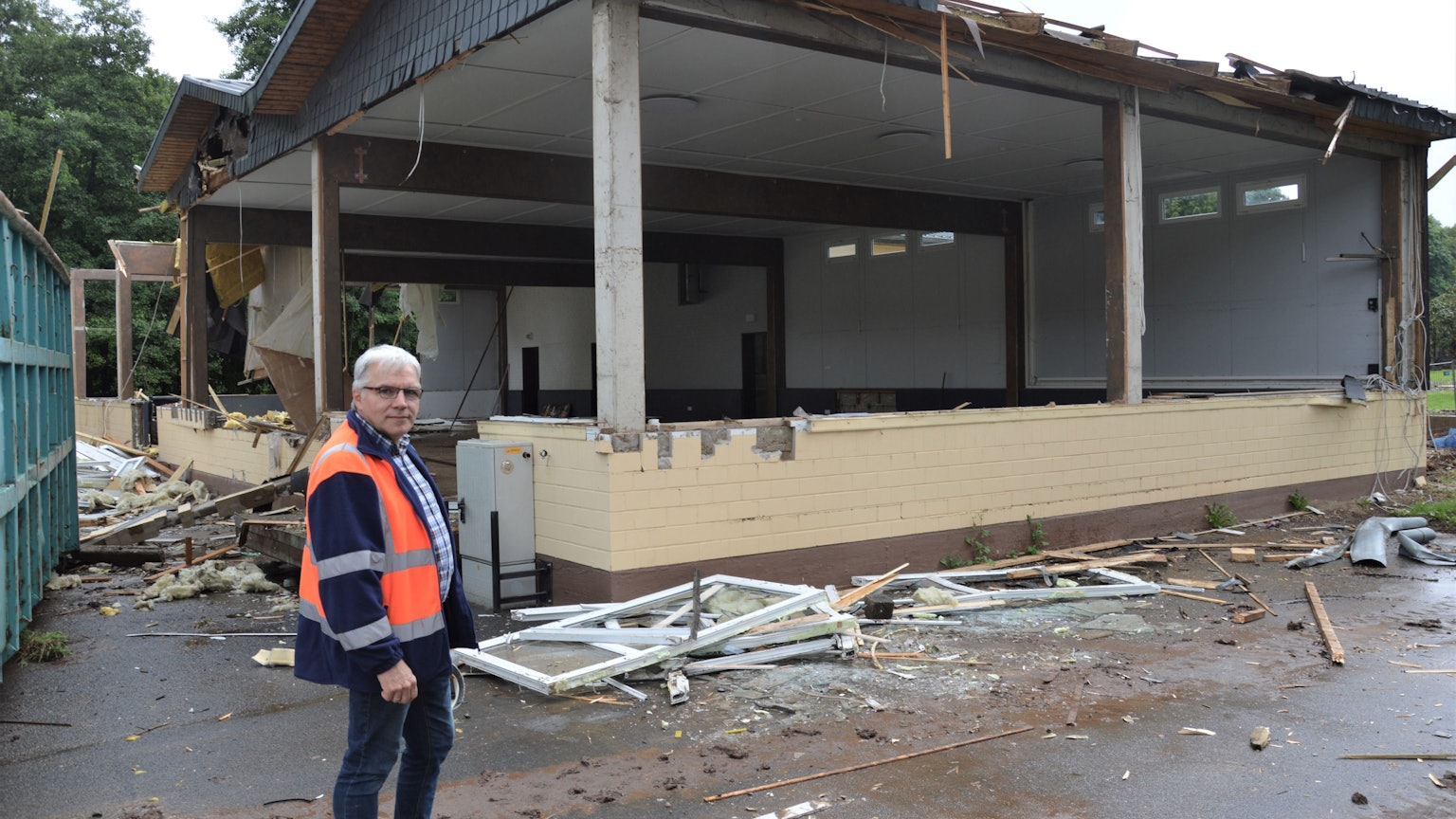 Ein Mann steht vor dem Sötenicher Bürgerhaus, das die Flut zerstört hat.
