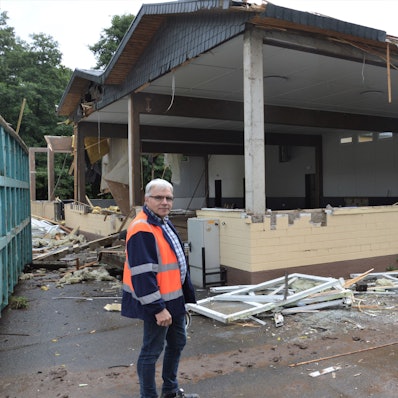 Ein Mann steht vor dem Sötenicher Bürgerhaus, das die Flut zerstört hat.