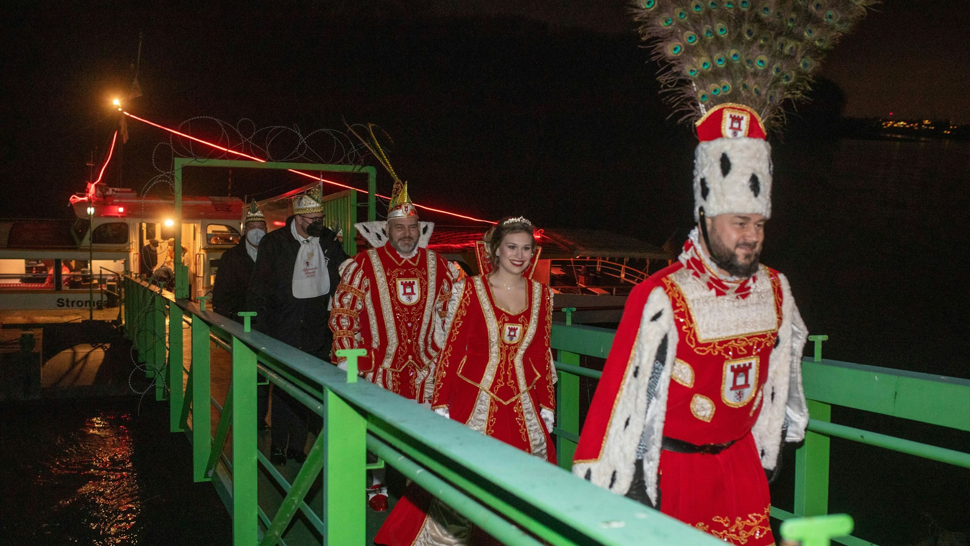 Das Porzer Dreigestirn um Prinz Markus II. (Lüsgen), Jungfrau Johanna (Langel) und Bauer André (Urban) kommt mit dem Schiff an und gehen über eine Brücke.