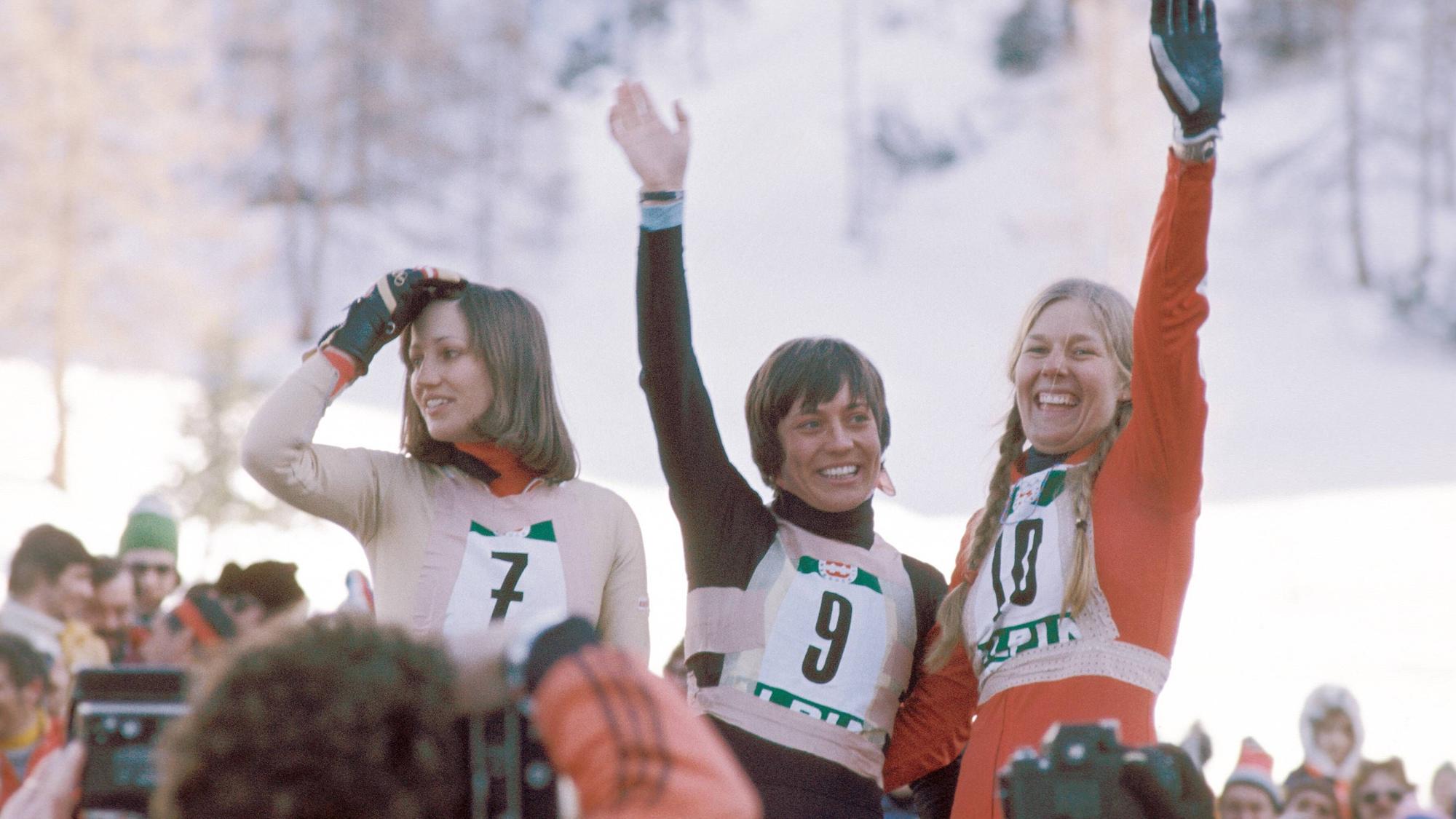 Jubel auf dem Podest mit den Platzierten nach dem Olympiasieg in der Abfahrt, bei dem Rosi Mittermaier die Startnummer 9 trug.
