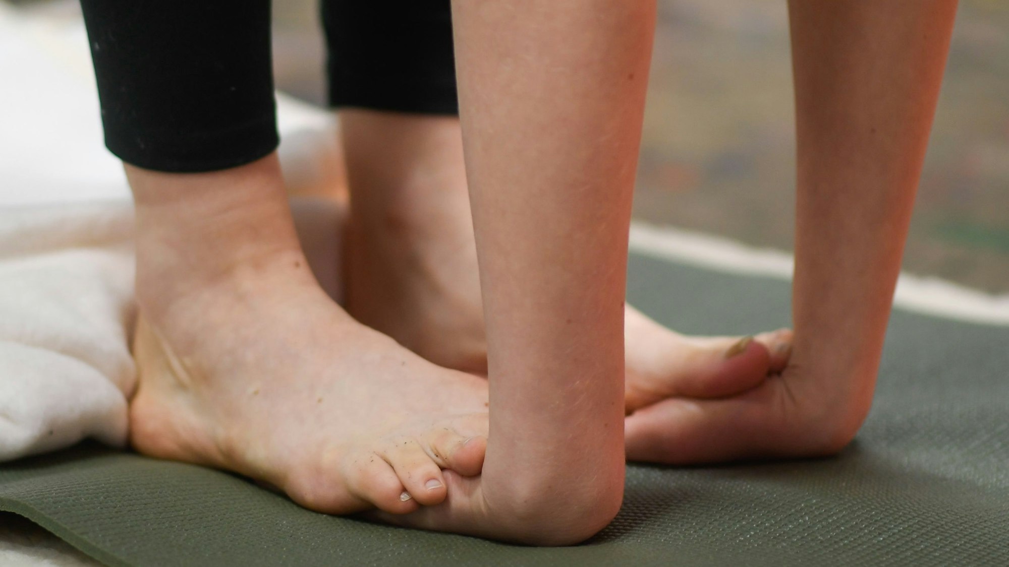 Stella Wolters klemmt sich ihre Hände beim herunterbeugen unter die Füße.