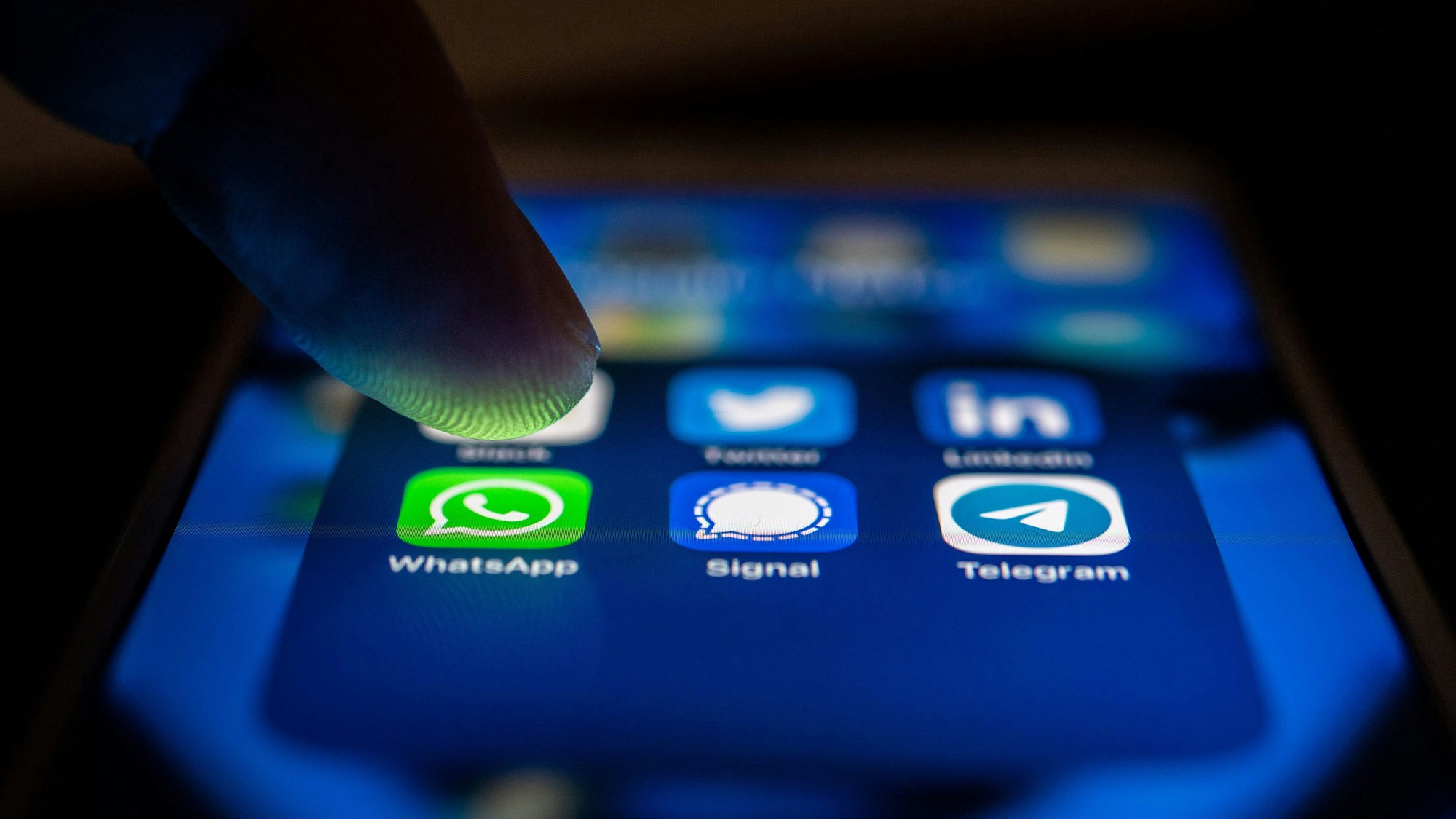 Auf einem Smartphone-Bildschirm sind nebeneinander die App-Icons von WhatsApp, Signal und Telegram zu sehen.