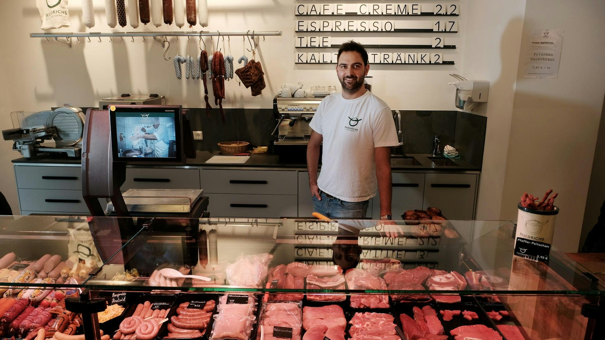Sebastian Friedrichs steht hinter einer Fleischtheke.