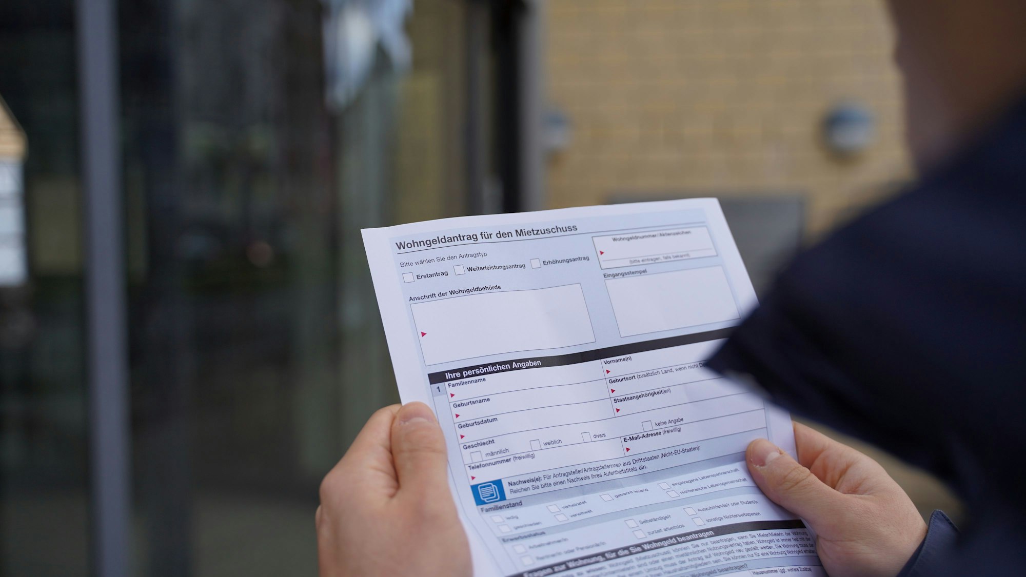 Ein Mann hält einen Antrag auf Wohngeld in der Hand.