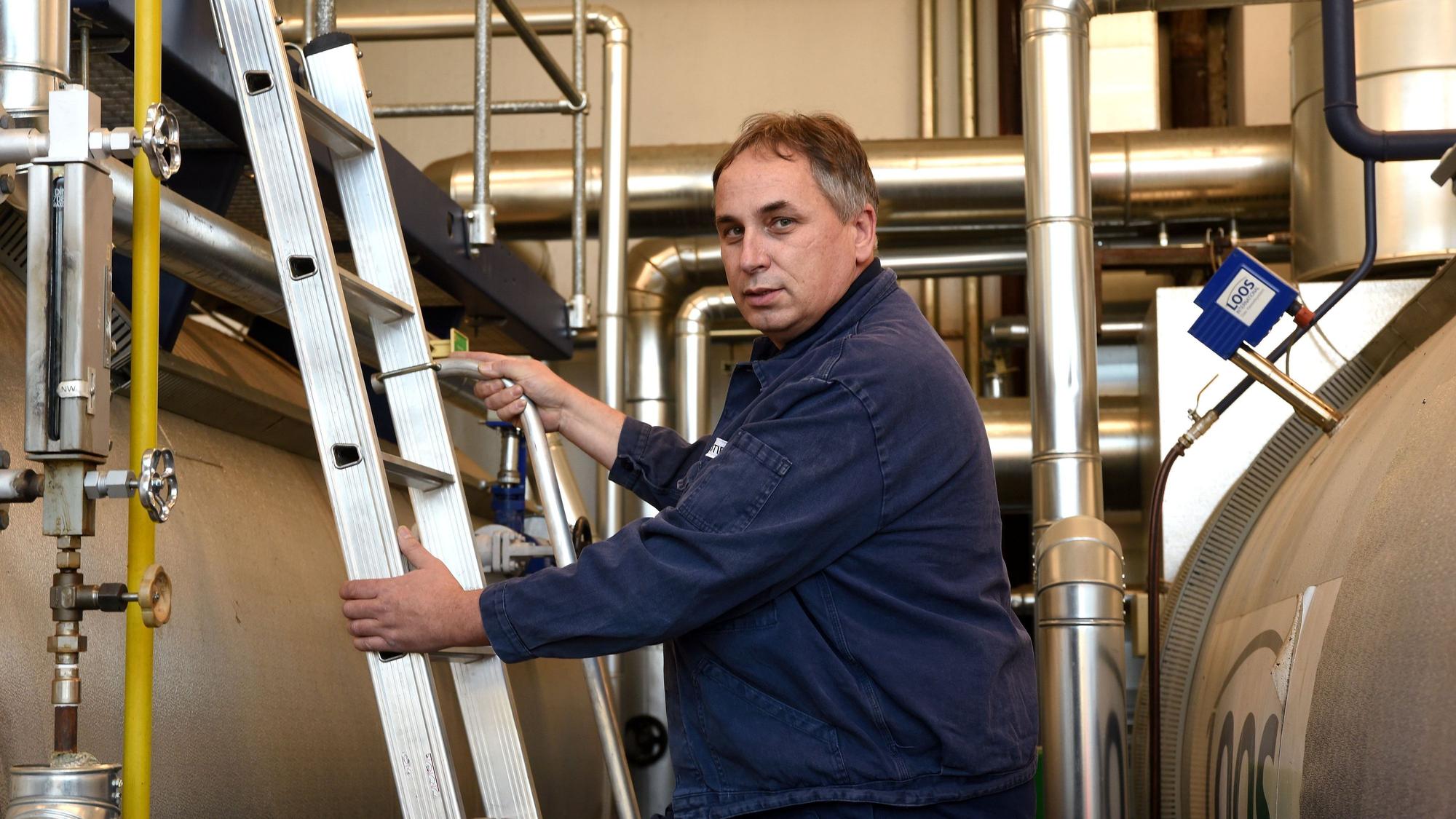 Wolfgang Stier klettert eine Leiter in der Fabrik hoch.