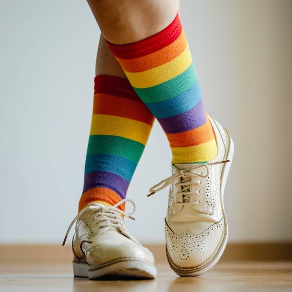 Beine einer Frau mit Socken in Regenbogenfarben