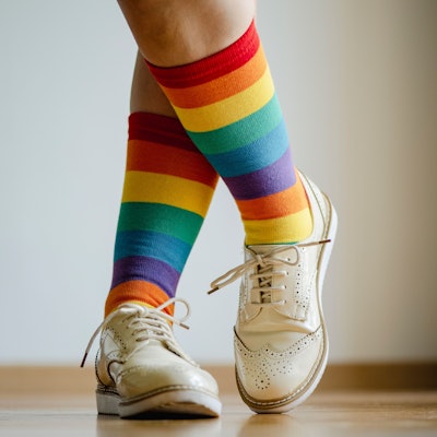 Beine einer Frau mit Socken in Regenbogenfarben