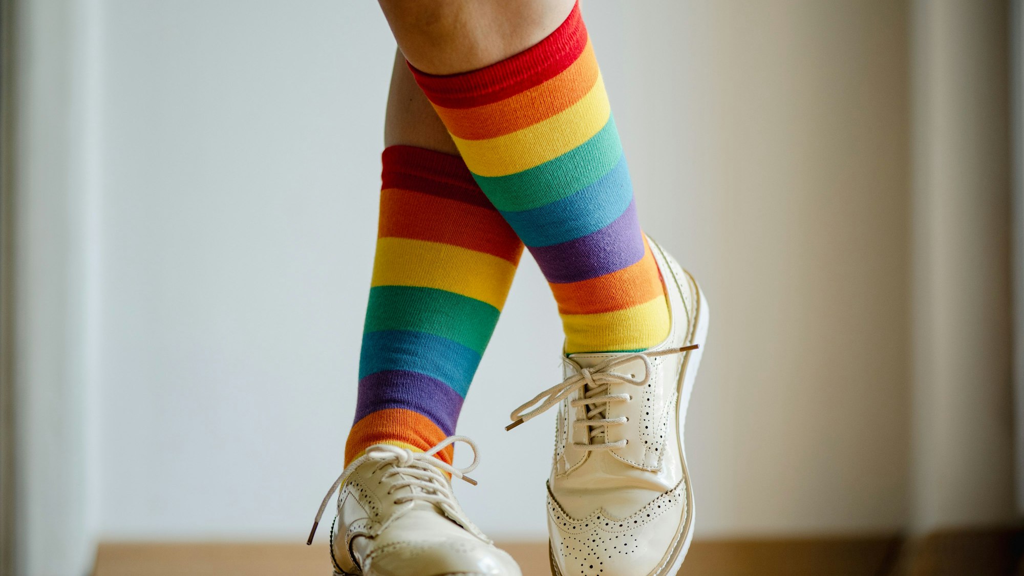 Beine einer Frau mit Socken in Regenbogenfarben