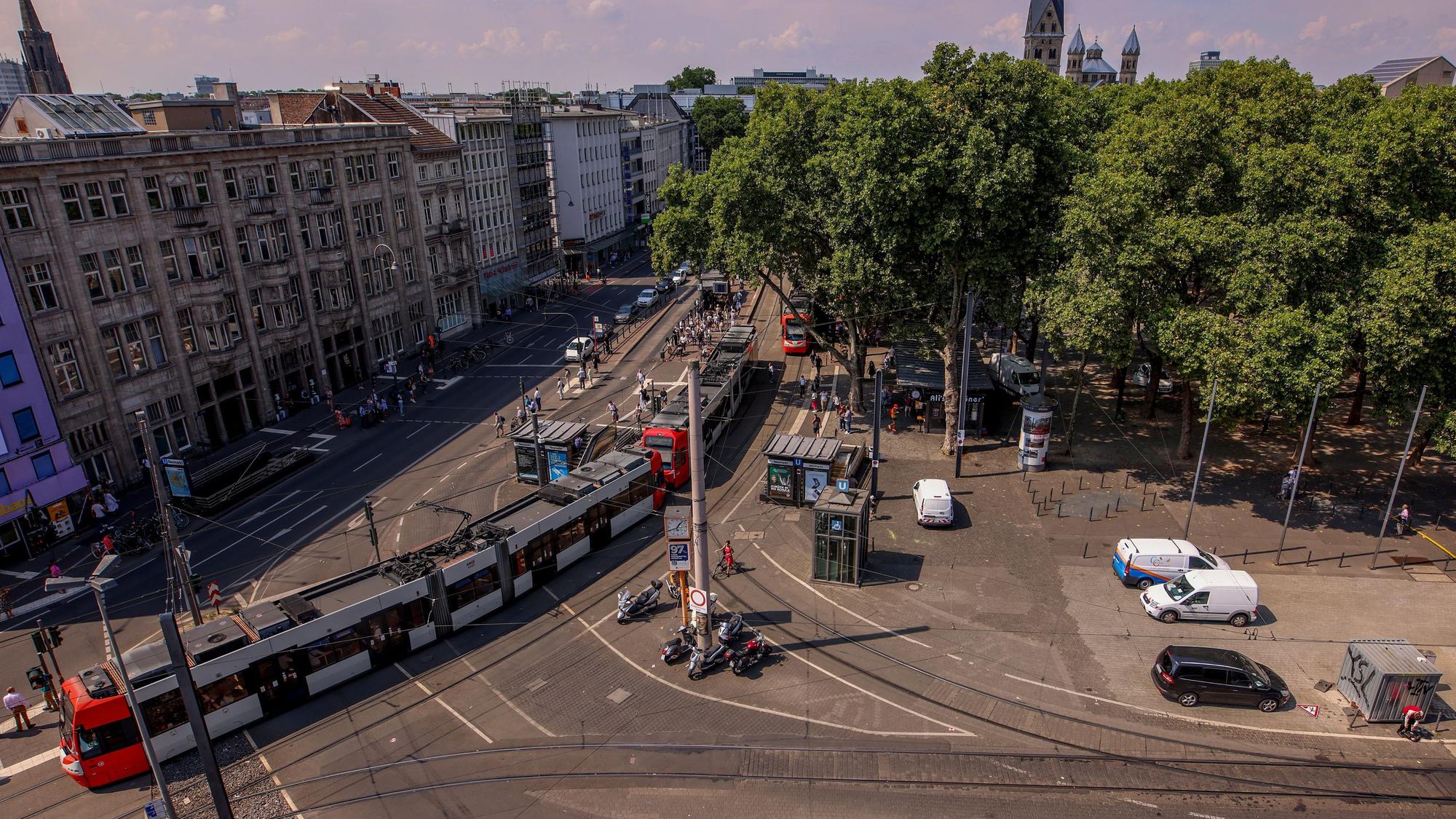 Die Luftaufnahme zeigt einen Teil des Neumarkts und der Cäcilienstraße. Eine Straßenbahn fährt Richtung Heumarkt.