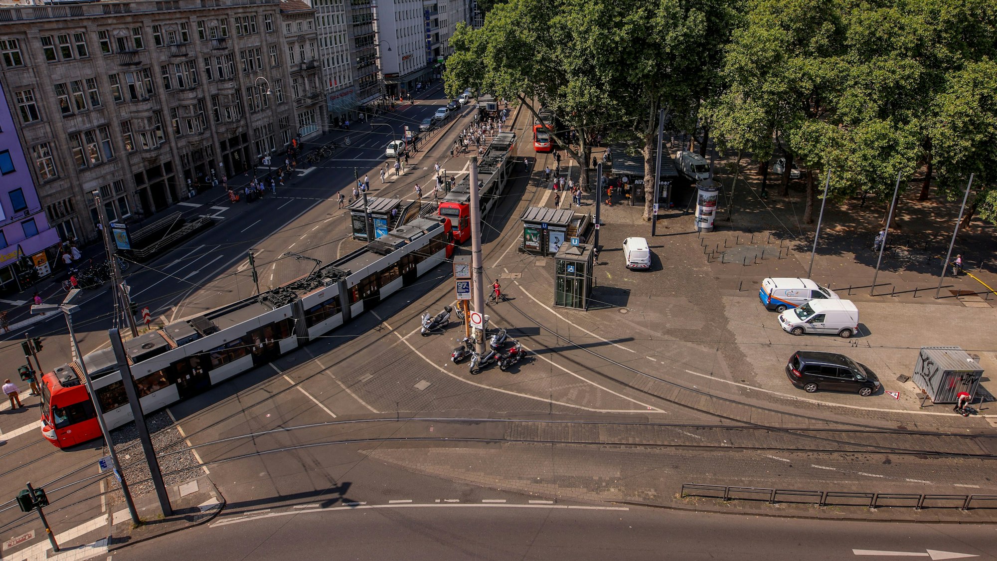 Ansicht des Neumarkt in Köln von oben: Es sind Bahnschienen, Straßenbahnen und eine Kreuzung zu sehen.
