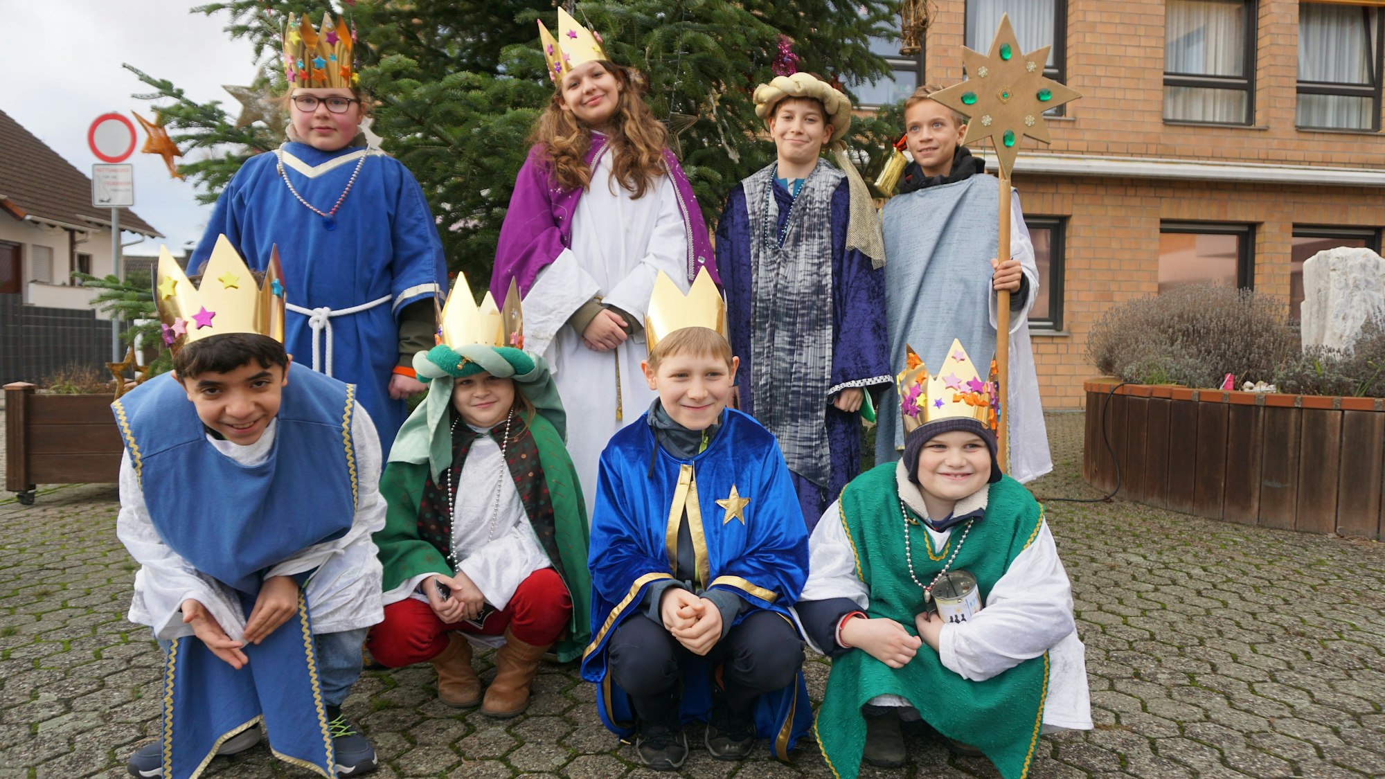Acht Kinder sind als Sternsinger verkleidet.