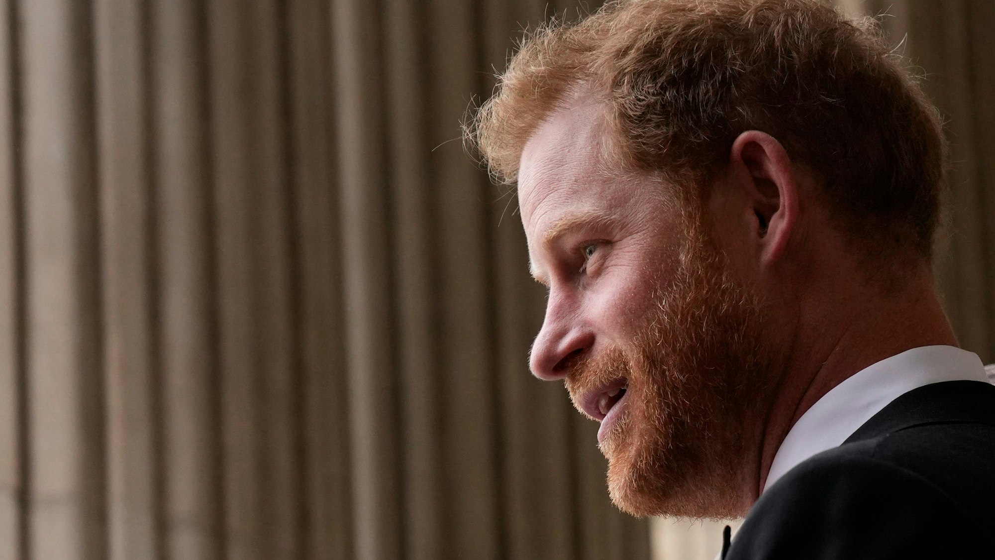 Prinz Harry, Herzog von Sussex, ist von der Seite fotografiert, er guckt aufgeregt.