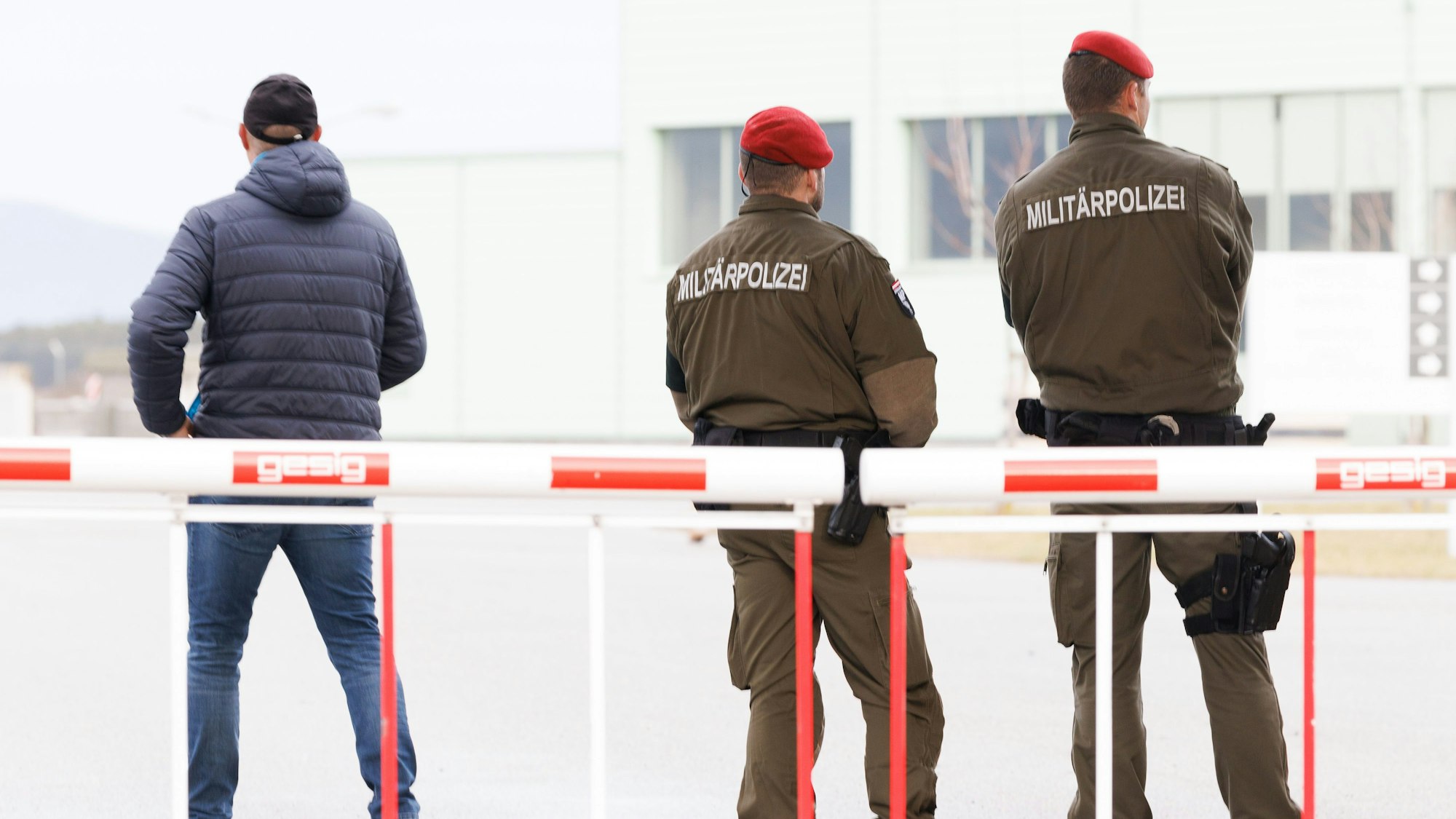 Zwei Polizisten stehen hintre einer Schranke