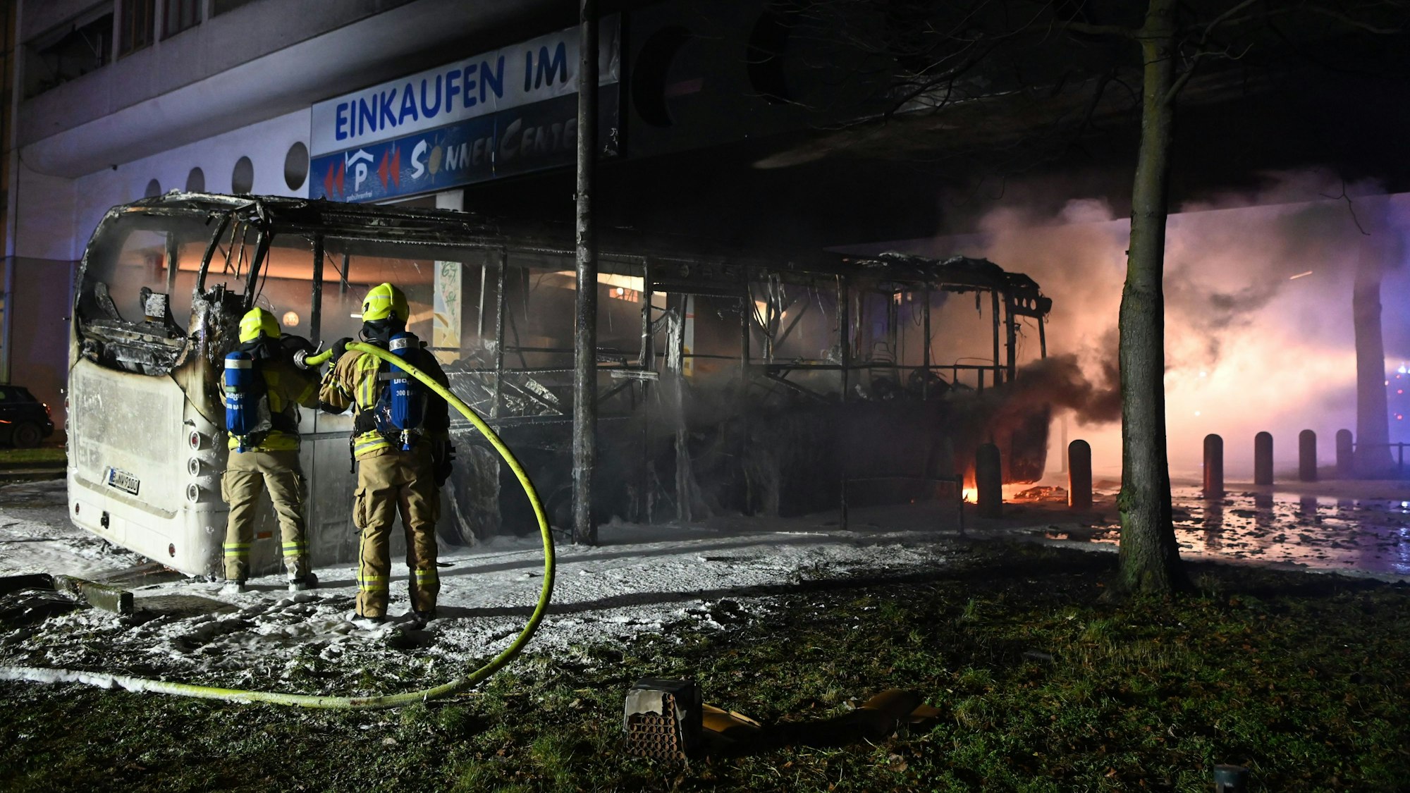 Feuerwehrmänner löschen an der Berliner Sonnenallee in der Silvesternacht einen Reisebus, der von Unbekannten angezündet worden war. Die Ausschreitungen in Berlin haben eine Debatte ausgelöst.