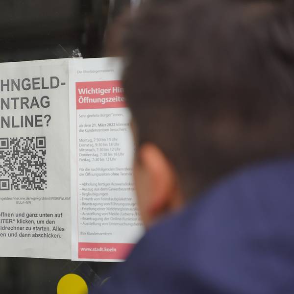 Im Fenster eine Kölner Behörde ist ein Hinweis auf die Online-Beantragung des Wohngeldes ausgehängt.