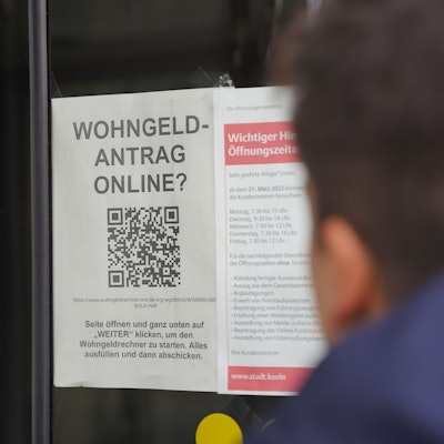Im Fenster eine Kölner Behörde ist ein Hinweis auf die Online-Beantragung des Wohngeldes ausgehängt.
