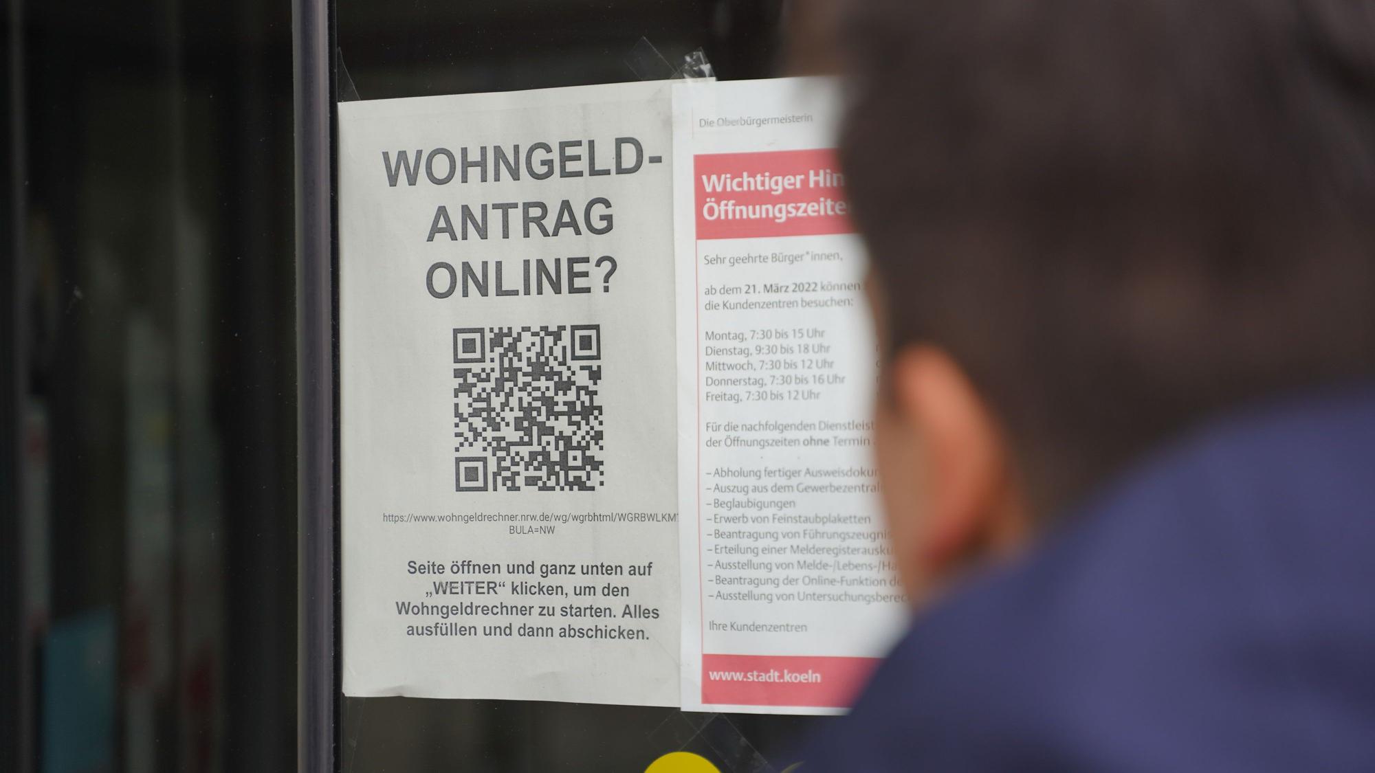 Im Fenster eine Kölner Behörde ist ein Hinweis auf die Online-Beantragung des Wohngeldes ausgehängt.