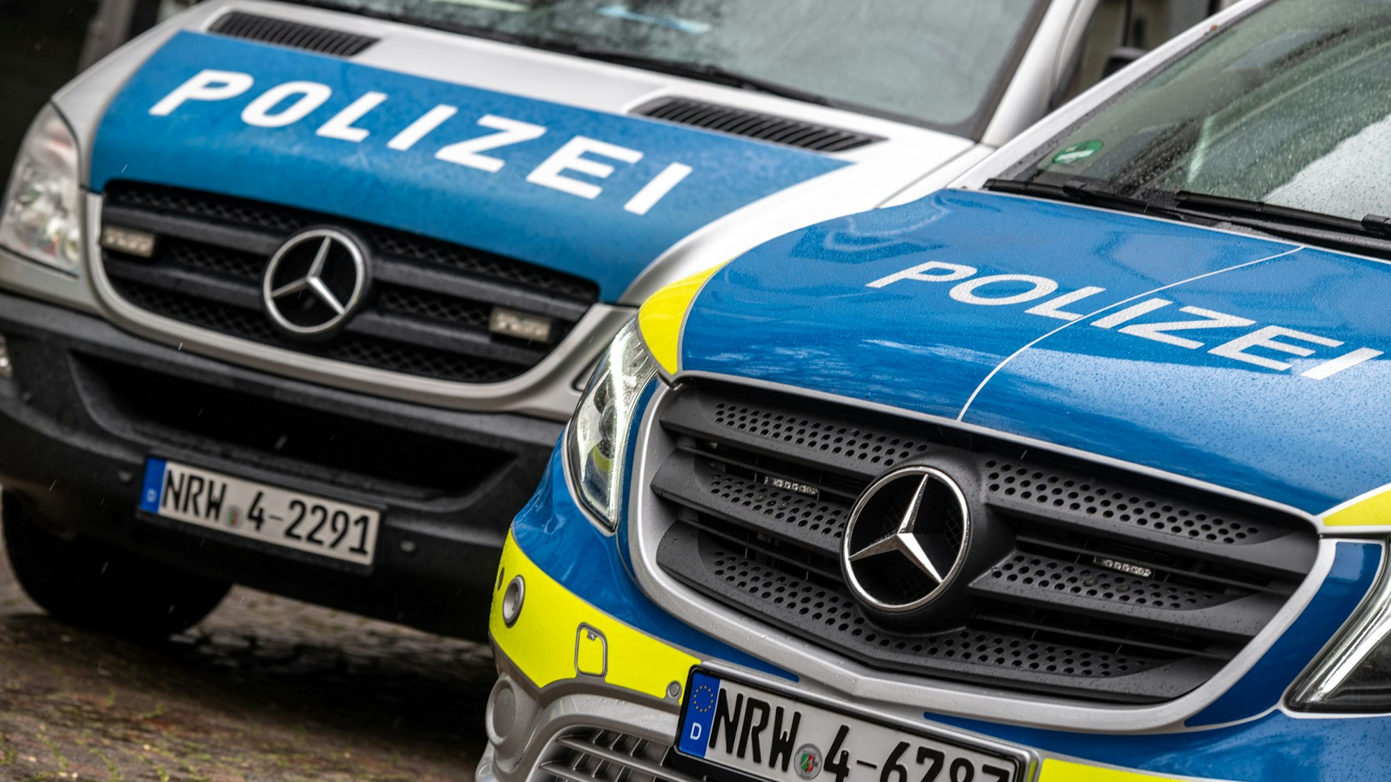 Zwei Polizeifahrzeuge stehen nebeneinander.