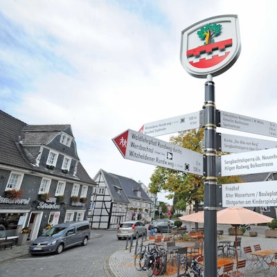 Wegweiser und Wappen auf dem Marktplatz in Witzhelden.