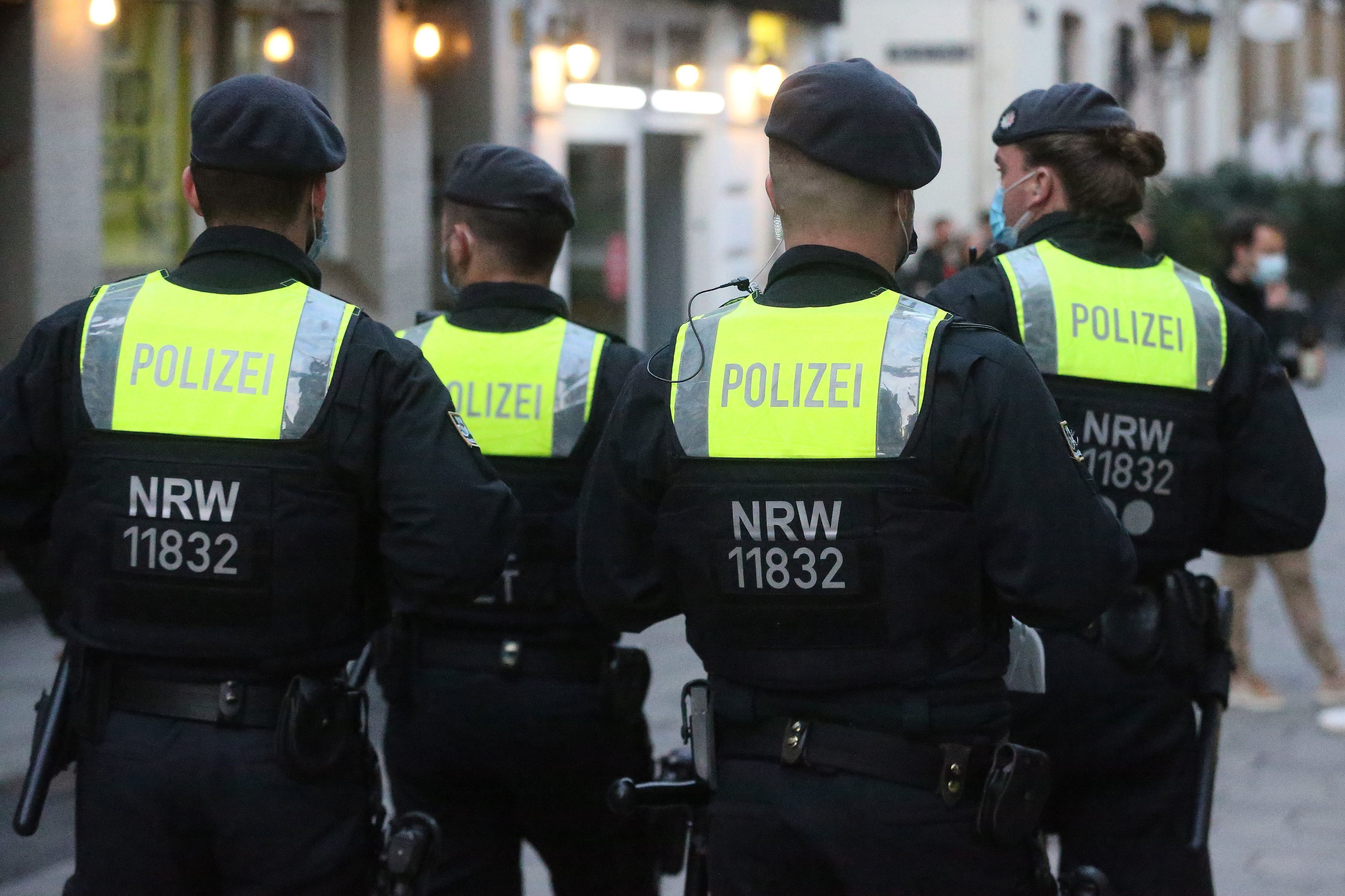 Polizisten auf Streife in der Düsseldorfer Altstadt, man sieht die Beamten von hinten.