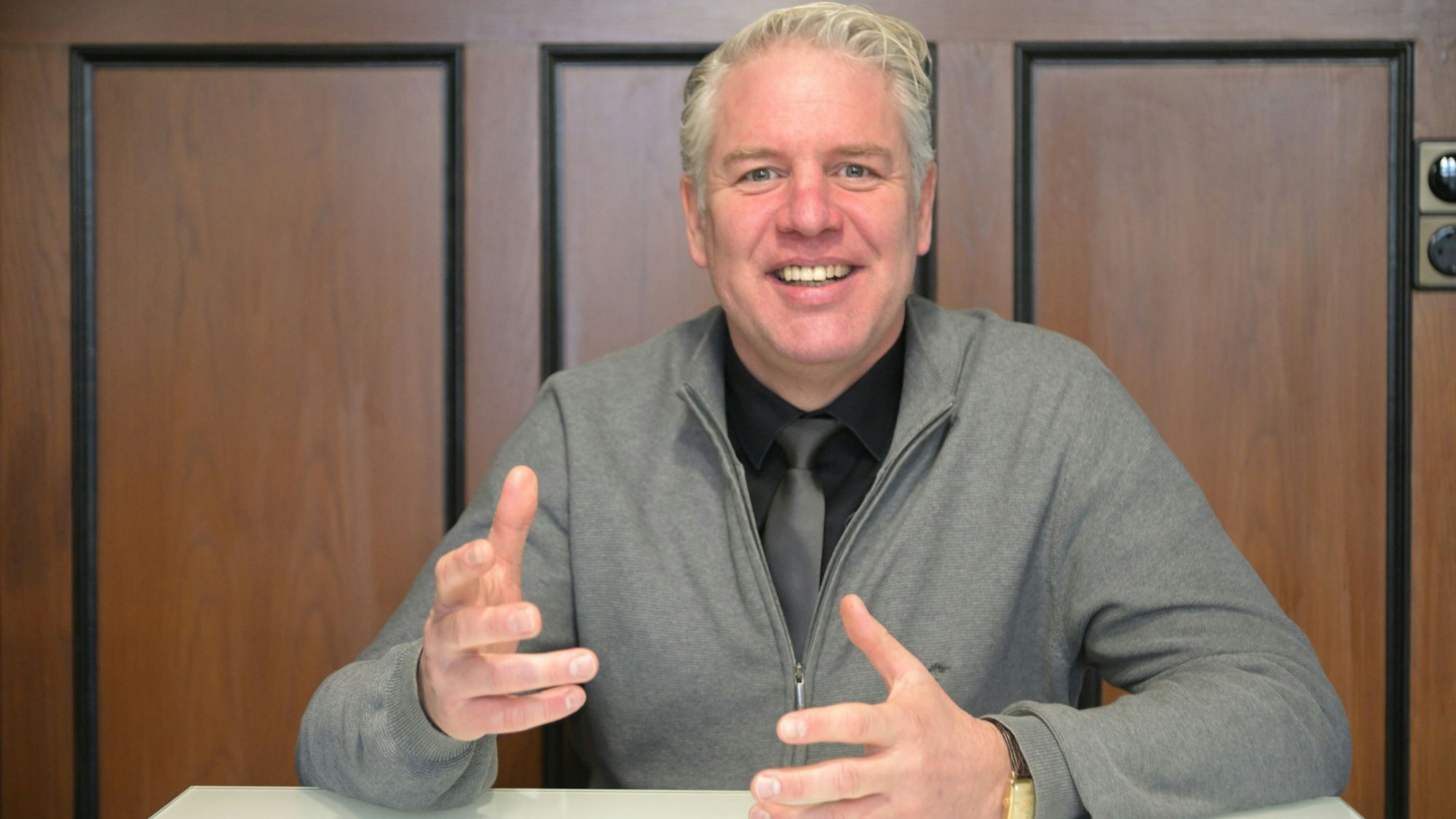 Odenthals Bürgermeister Robert Lennerts sitzt an einem Tisch im Odenthaler Rathaus und spricht.