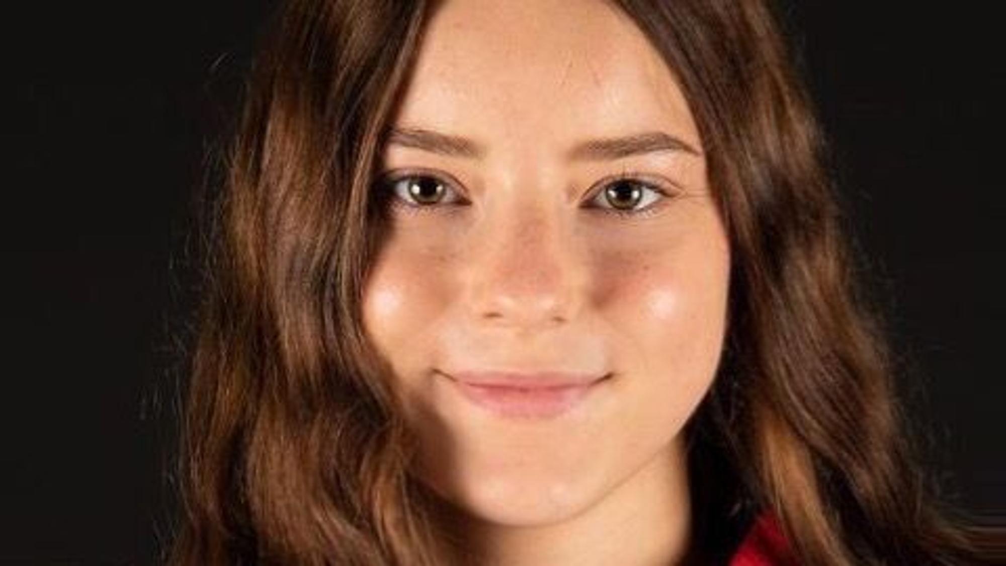Lea Badura guckt in die Kamera. Sie hat lange braune Haare und trägt ein Eishockey-Trikot.
