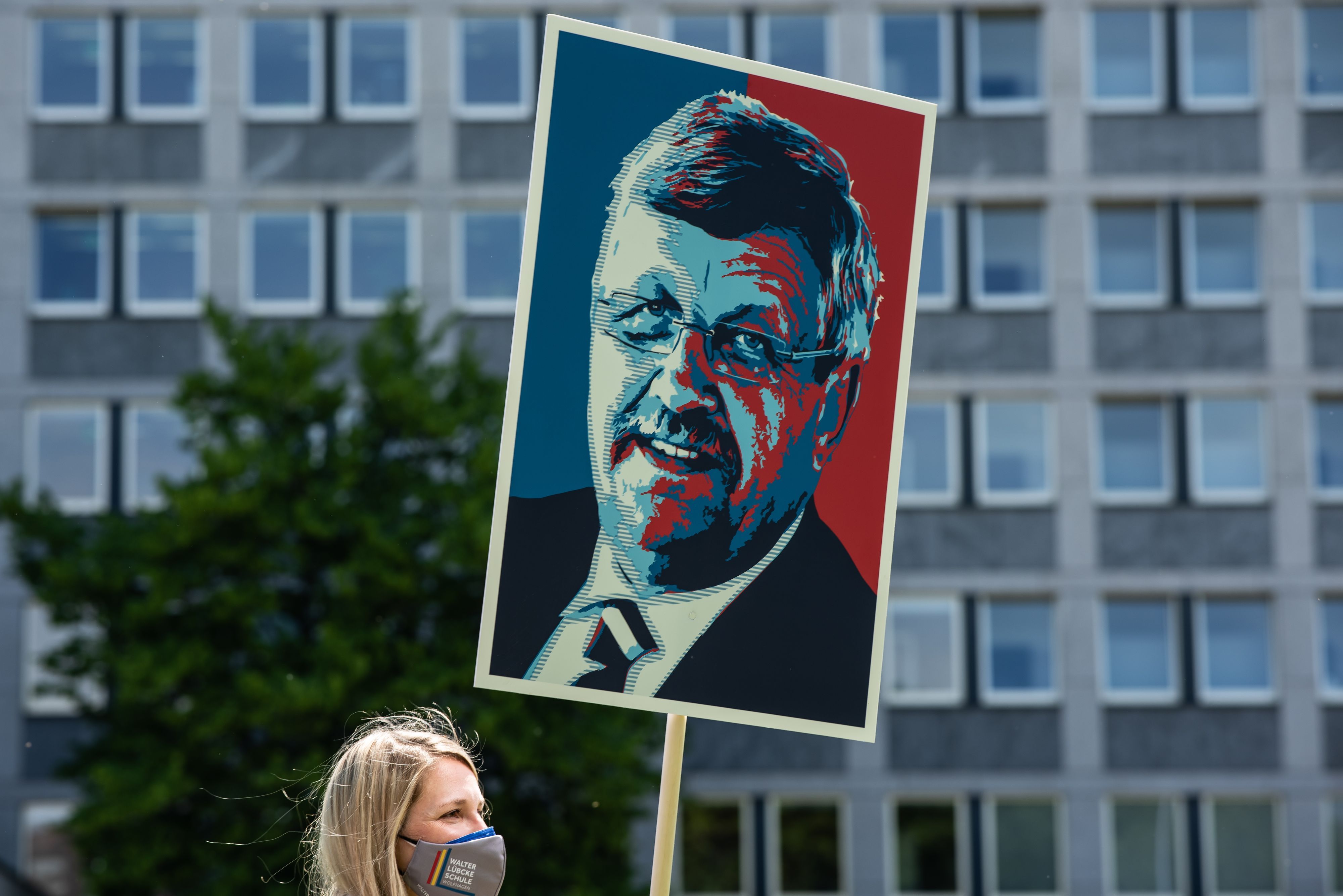 Eine Lehrerin trägt ein Plakat mit dem Portrait von Walter Lübcke zum Gedenken an den ermordeten Kasseler Regierungspräsidenten.