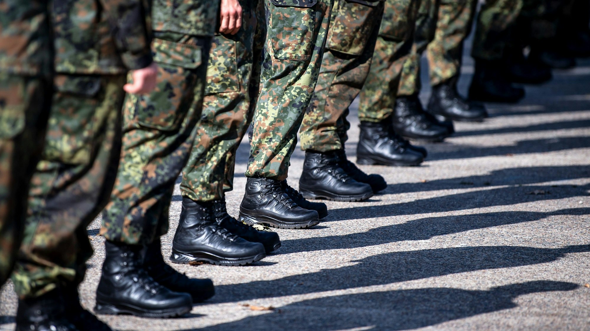 Soldaten der Bundeswehr stehen aufgereiht in einer Linie auf einem Appellplatz.