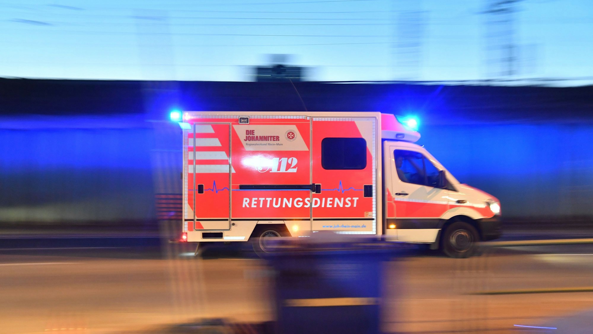 Ein Rettungswagen ist mit eingeschaltetem Blaulicht im Einsatz (Symbolbild)
