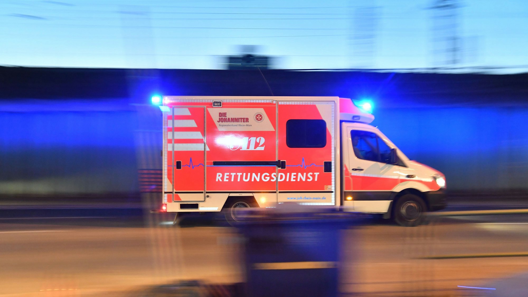 Ein Rettungswagen ist mit eingeschaltetem Blaulicht in der Nacht im Einsatz. (Symbolbild)