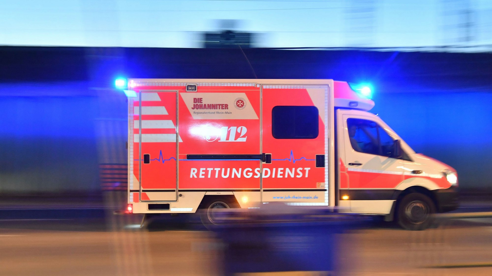 Ein Rettungswagen ist mit eingeschaltetem Blaulicht im Einsatz.