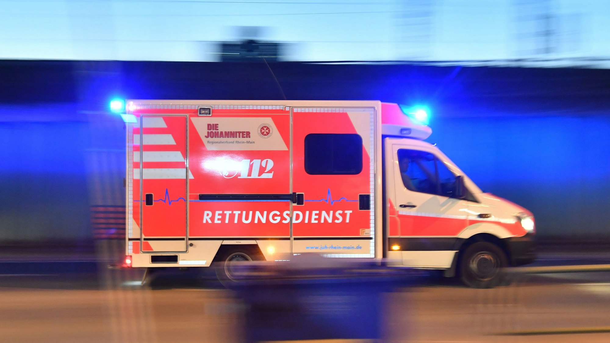 Ein Rettungswagen ist mit eingeschaltetem Blaulicht im Einsatz.
