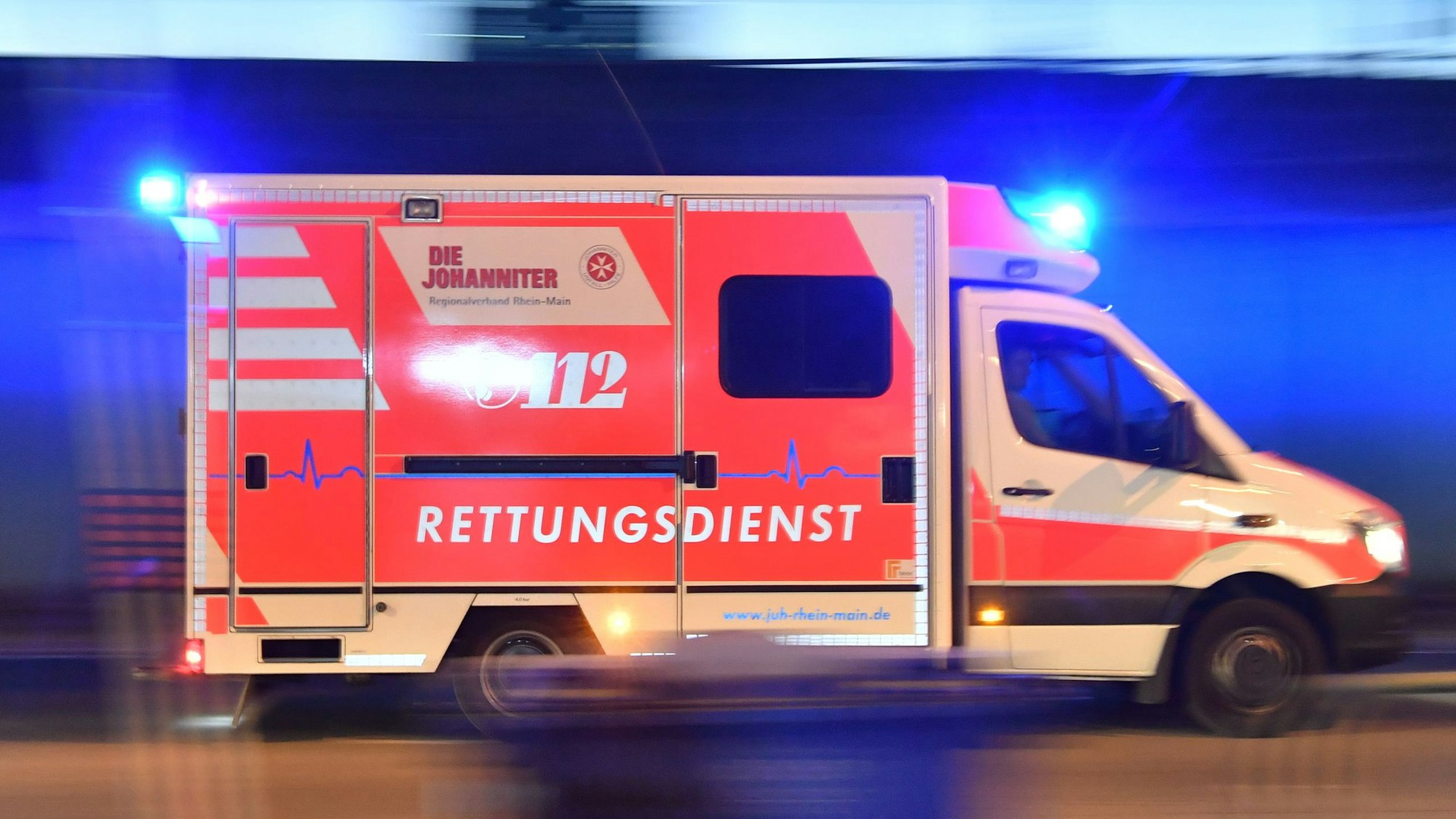 Ein Rettungswagen ist mit eingeschaltetem Blaulicht im Einsatz.