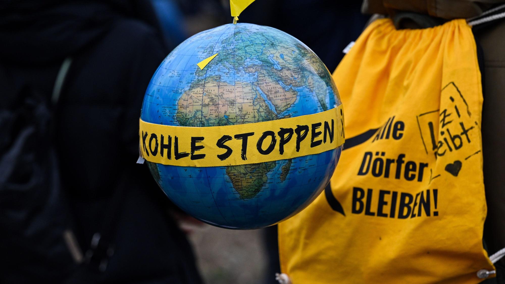 Ein Globus mit einem Fähnchen mit dem Ortsnamen "Lützerath" und dem Schriftzug "Kohle stoppen".