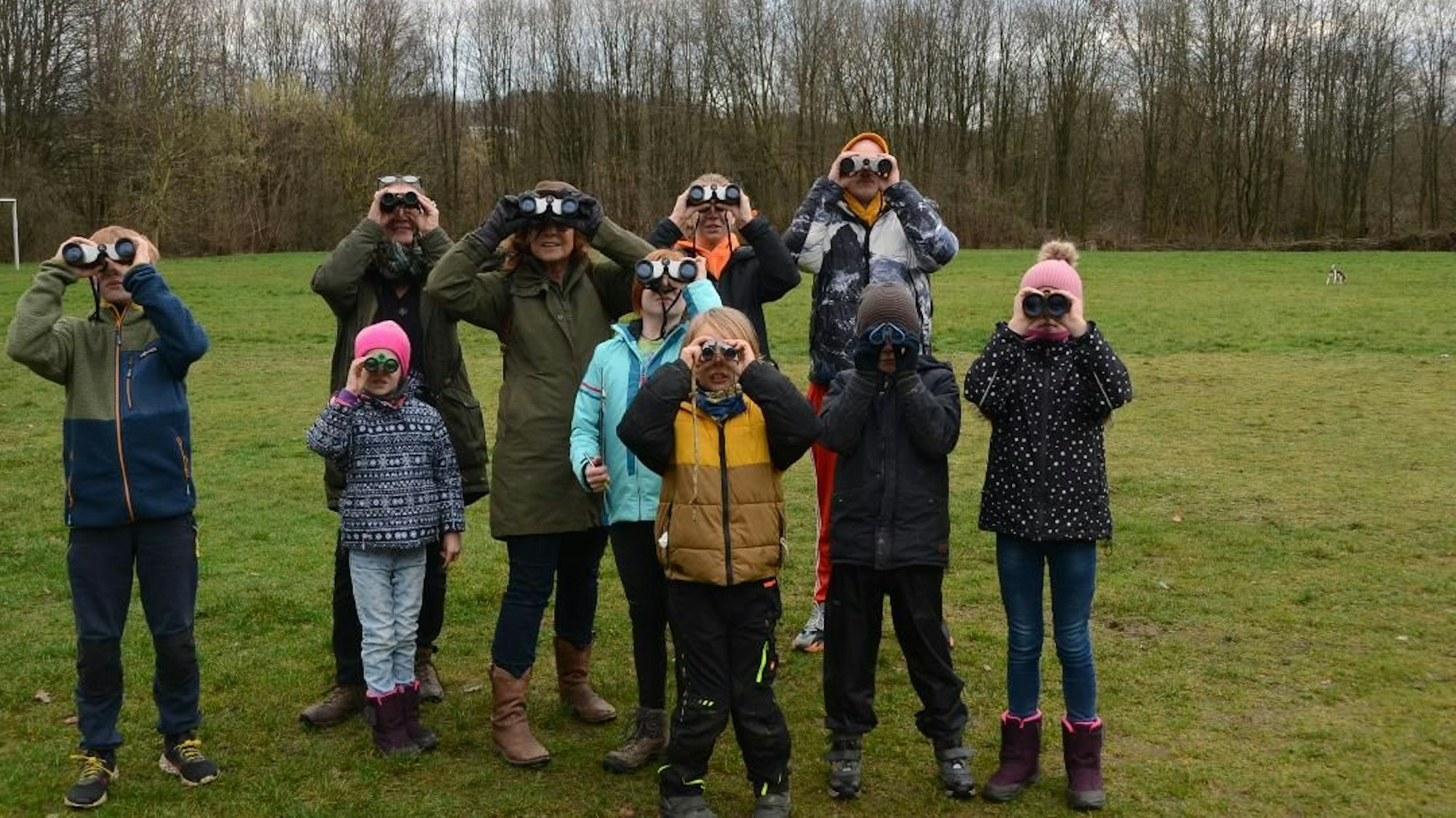 Eine Gruppe Kinder späht durch Ferngläser.