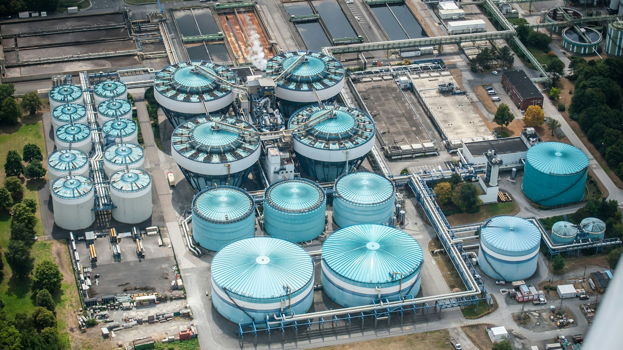 Luftbild der türkisblauen Stapeltanks in der Kläranlage von Currenta in Leverkusen-Bürrig.