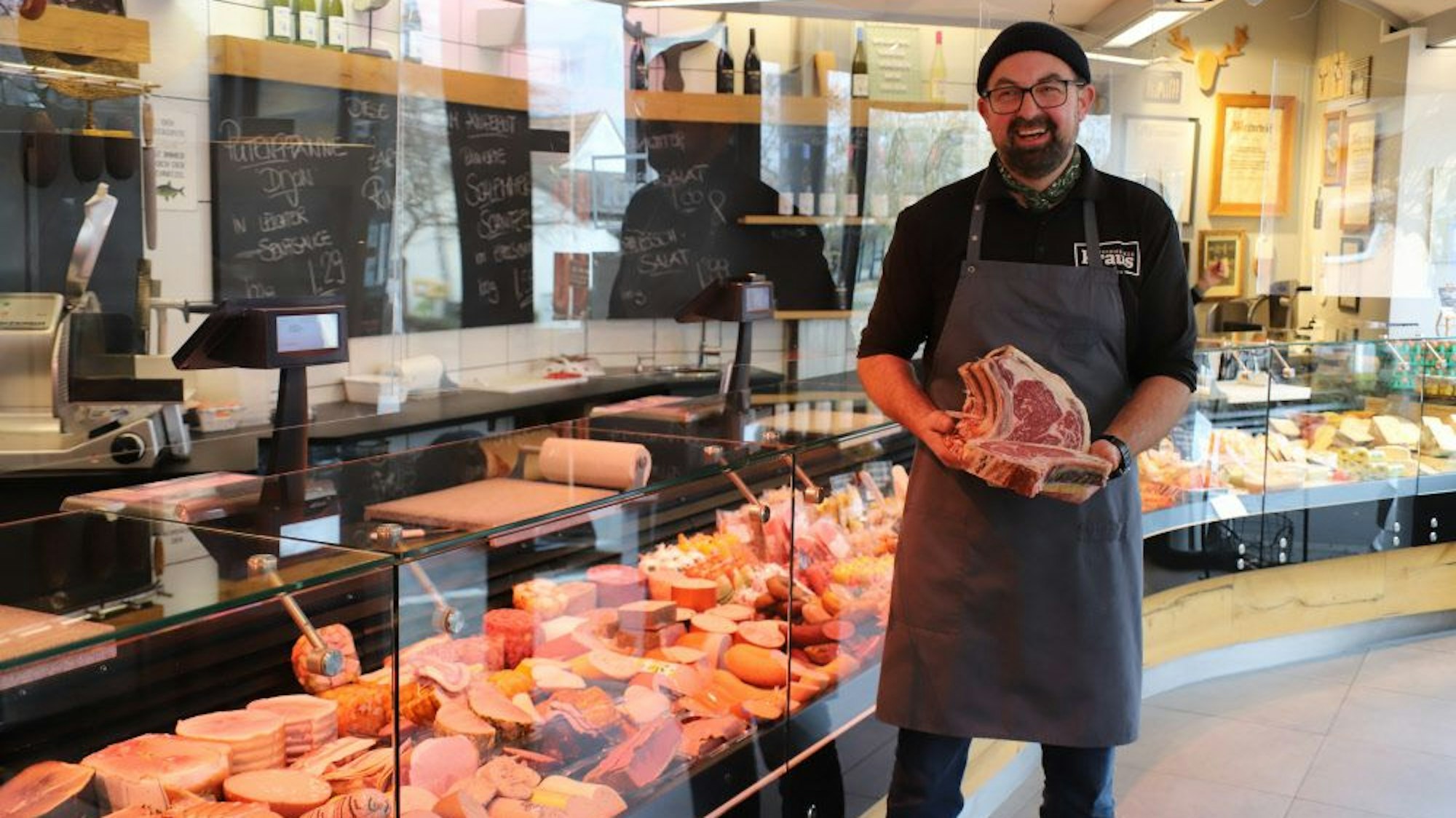 Ein Metzger steht vor seiner Ladentheke.